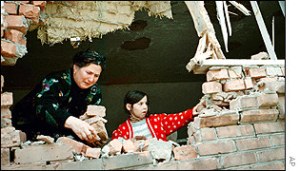woman behind broken wall in Chechnya
